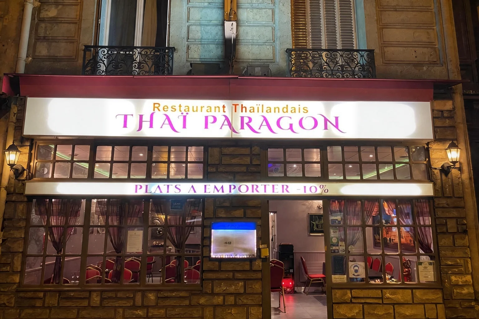 Devanture de Thaï Paragon le soir, enseigne lumineuse et vitrines éclairées